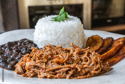 Bild auf Leinwand Plato tradicional venezolano de pabellón criollo con carne mechada, arroz, caraotas negras y plátanos fritos