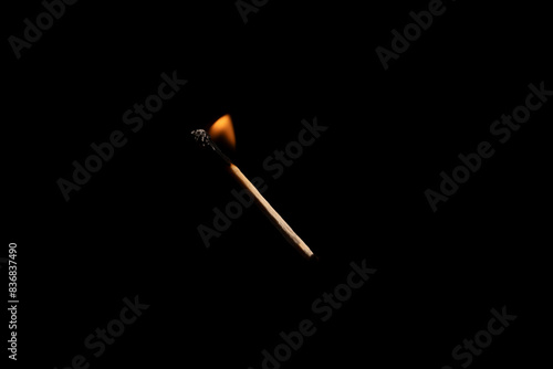 Lit falling match on a black background.