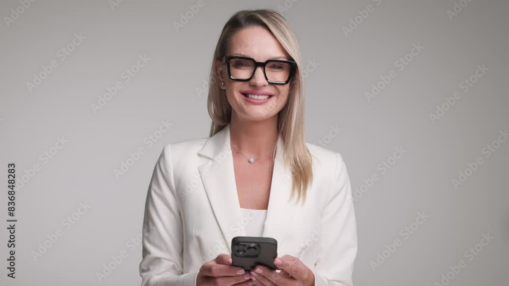 businesswoman reading an email on smartphone while making thumbs up sign and smiling businesswoman reading an email on smartphone while making thumbs up sign and smiling