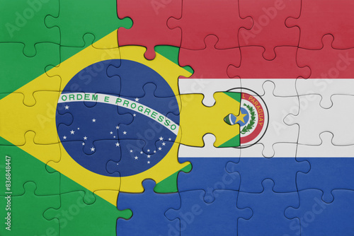 puzzle with the colourful national flag of paraguay and flag of brazil . photo