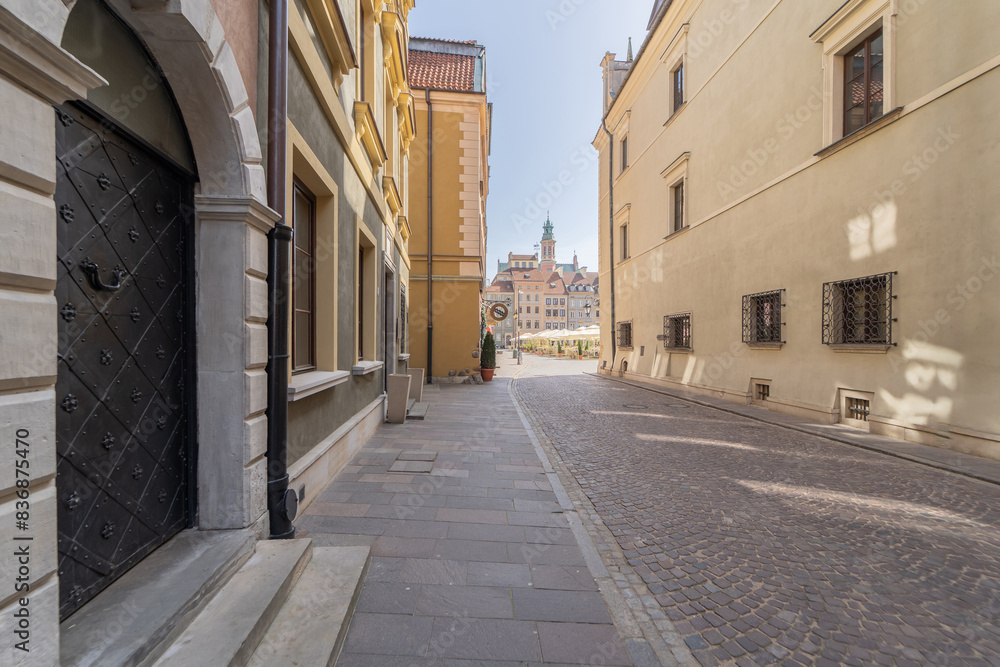 A picturesque narrow cobblestone alley leading to a historic town square, flanked by classic European buildings. The scene exudes old-world charm and architectural beauty. A picturesque narrow cobblestone alley leading to a historic town square, flanked by classic European buildings. The scene exudes old-world charm and architectural beauty.