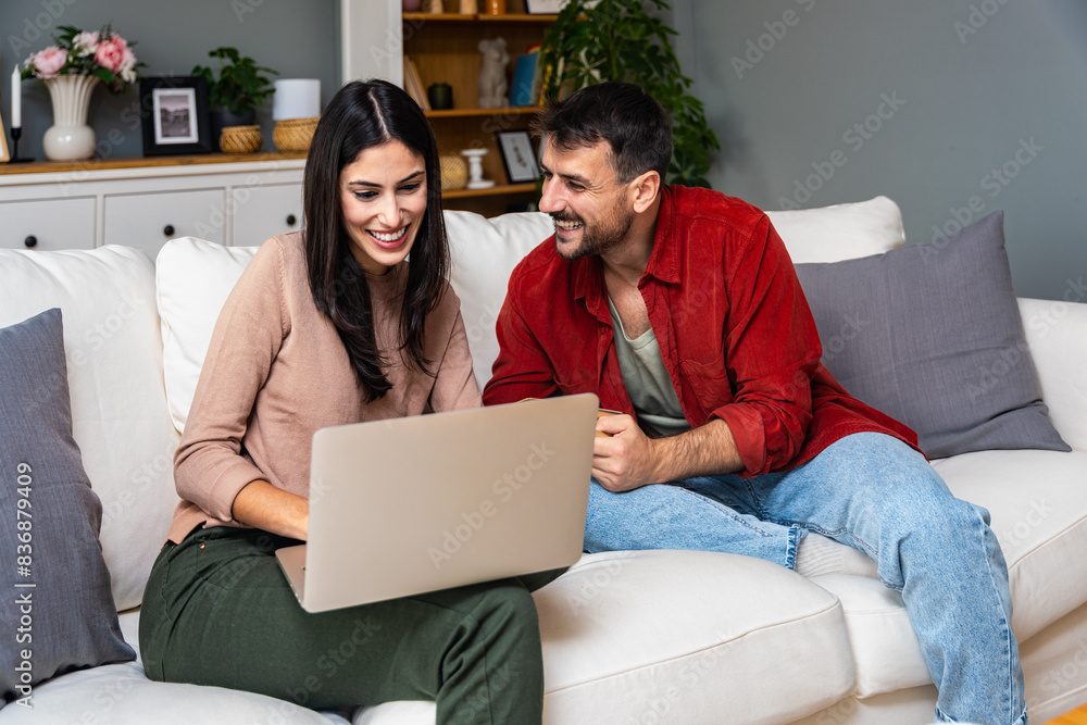 Leisure and people concept happy couple with laptop computer and book at home. Man and woman boyfriend and girlfriend or roommate free time on sofa reading and surfing the internet. Weekend activities Leisure and people concept happy couple with laptop computer and book at home. Man and woman boyfriend and girlfriend or roommate free time on sofa reading and surfing the internet. Weekend activities