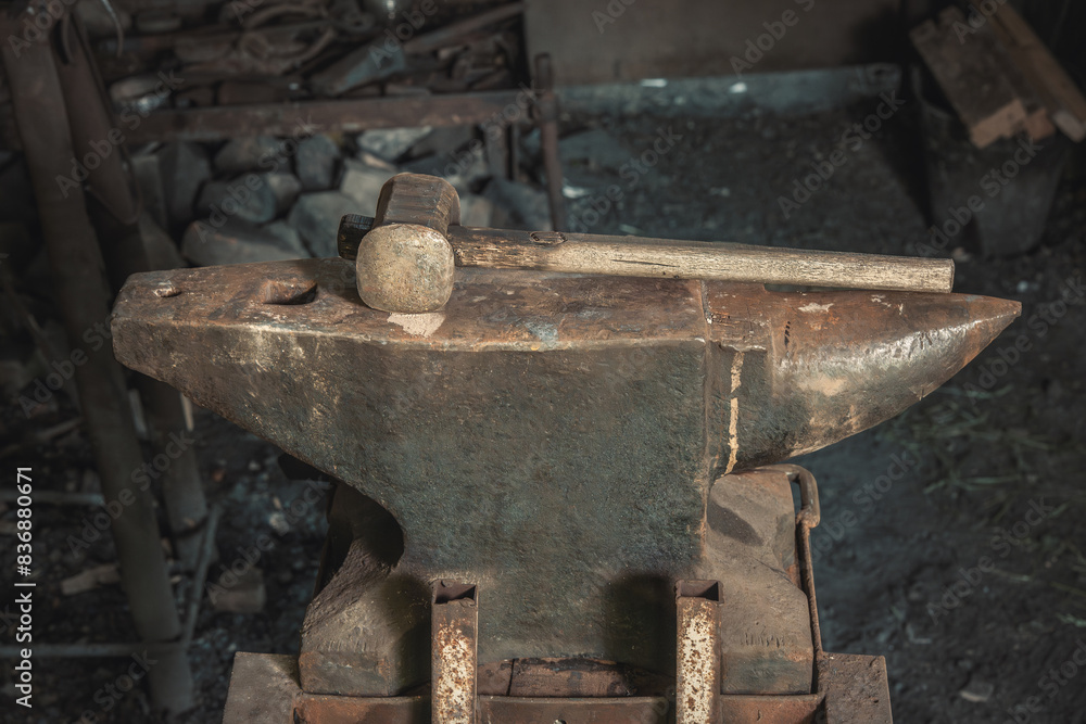 Rusty blacksmith's anvil and hammer in an abandoned workshop. Close-up Rusty blacksmith's anvil and hammer in an abandoned workshop. Close-up