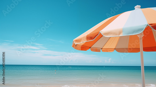 Gros plan sur un parasol déployé au bord de mer. Vue sur un paysage maritime, eau, océan. Plage, sable. Vacances, été, soleil. Bleu. Pour conception et création graphique. 