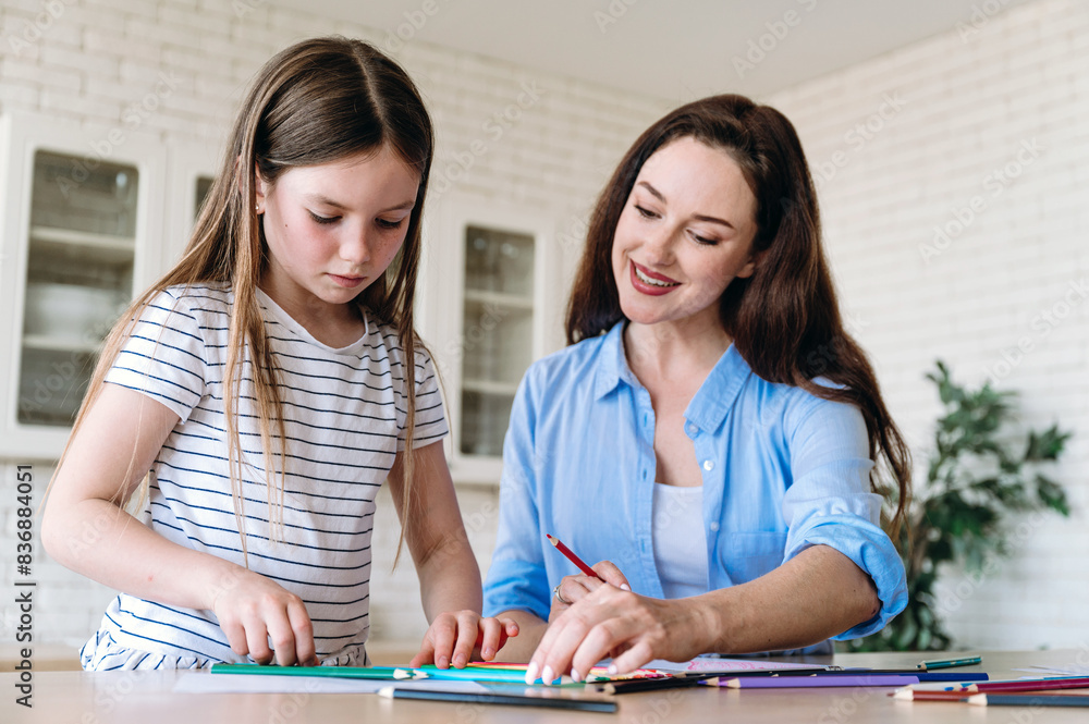 Loving smiling mother helping daughter choose color of pencil for drawing Loving smiling mother helping daughter choose color of pencil for drawing