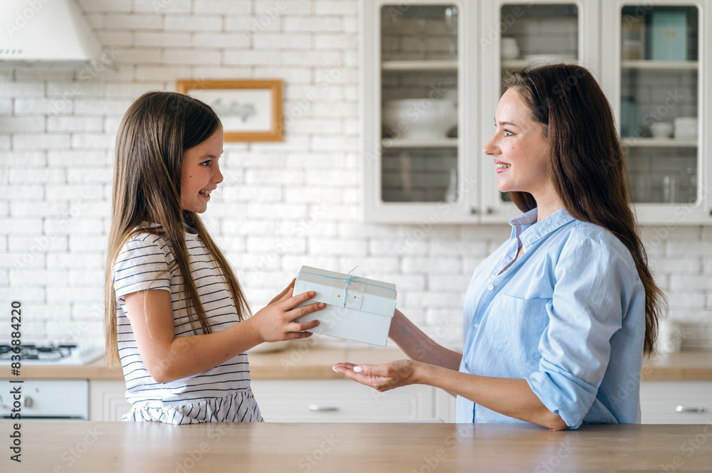 Smiling daughter making surprise for mother, giving gift box Smiling daughter making surprise for mother, giving gift box