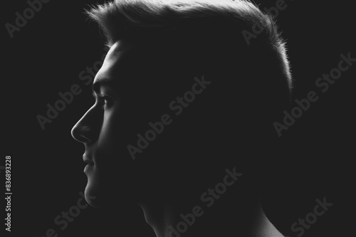 studio shot profile silhouette of young man © alisaaa