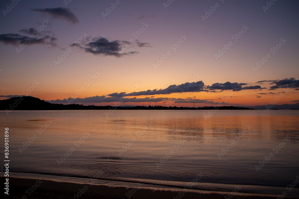 Obraz premium A tranquil beach bathed in a serene sunrise Nature composition.