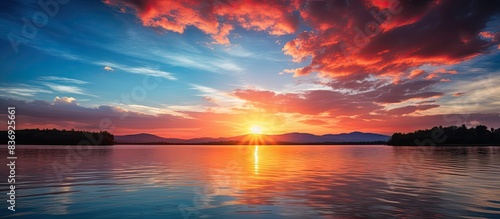 A serene sunset over a tranquil lake with vibrant hues in the sky, captured in a high-quality copy space image.