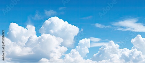 Fluffy white clouds floating in a clear blue sky, perfect for a copy space image. photo