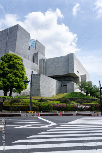 Photography Modern concrete building with geometric architecture near a crosswalk under a bright blue sky