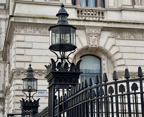 A low angle view of the entrance to Downing Street with the road name sign on the wall of a building in the background, Westminster, London, UK. 