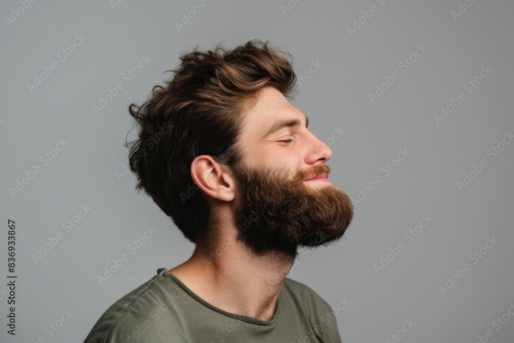 A close up of a man with beard and closed eyes looking to a side A close up of a man with beard and closed eyes looking to a side