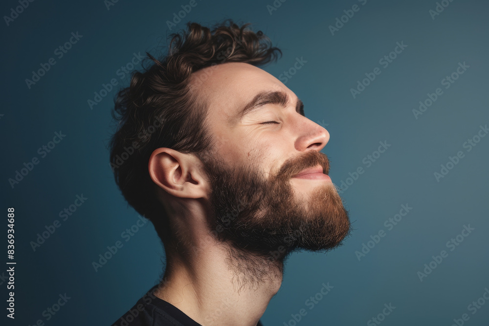 A close up of a man with beard and closed eyes looking to a side A close up of a man with beard and closed eyes looking to a side