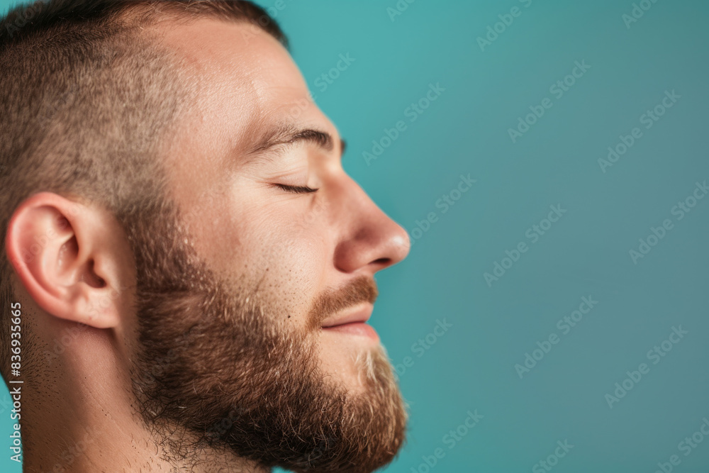 Fototapeta premium A close up of a man with beard and closed eyes looking to a side