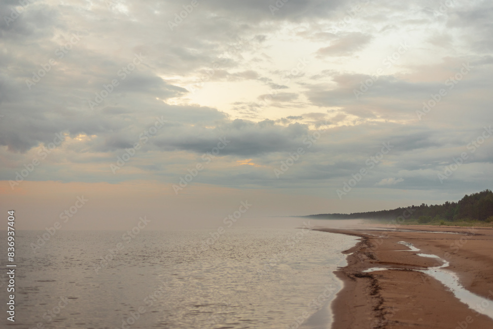 Empty sandy beach of Baltic sea covered with fog after rain during the sunset at summer Empty sandy beach of Baltic sea covered with fog after rain during the sunset at summer