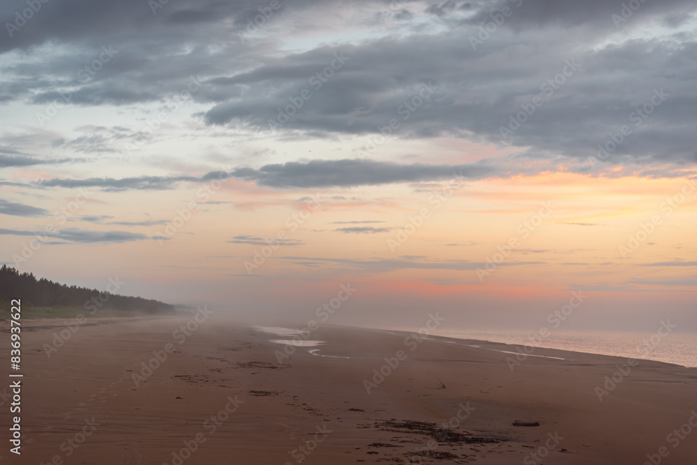 Empty sandy beach of Baltic sea covered with fog after rain during the sunset at summer Empty sandy beach of Baltic sea covered with fog after rain during the sunset at summer