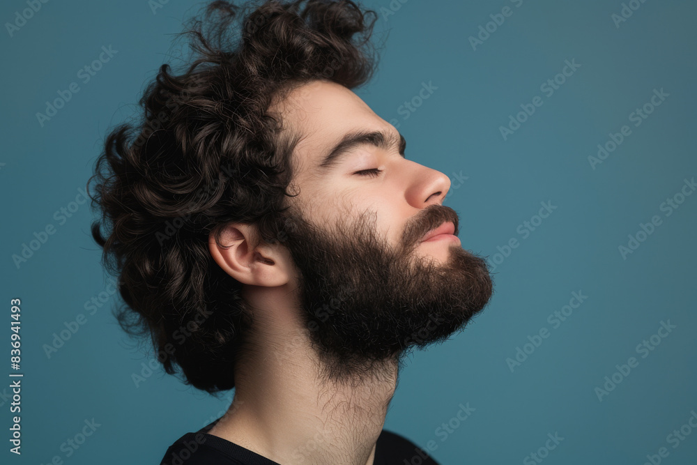 Fototapeta premium A close up of a man with beard and closed eyes looking to a side