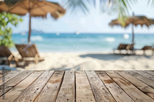 Wooden table on beach background with chairs and parasol.