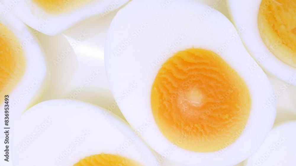 Sliced boiled eggs arranged elegantly, revealing their immaculate whites enveloping velvety, golden yolks. The yolks exude richness against the backdrop of the smooth, tender egg whites.
Sliced boiled eggs arranged elegantly, revealing their immaculate whites enveloping velvety, golden yolks. The yolks exude richness against the backdrop of the smooth, tender egg whites.