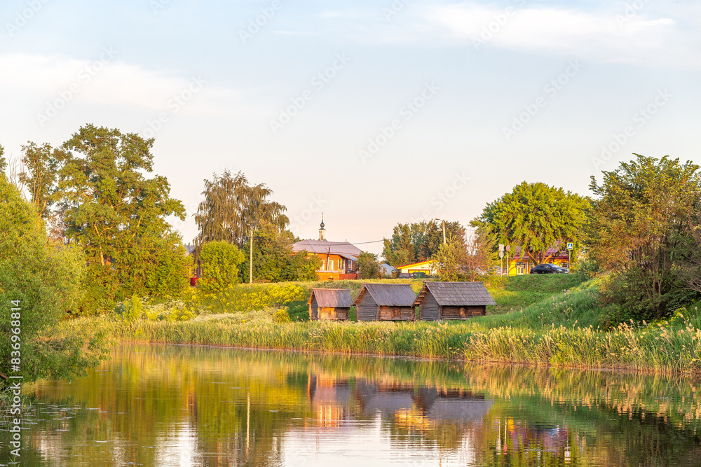Fototapeta premium Russia. View of the old village. A river, a storage building on the shore, a sauna, a storeroom.