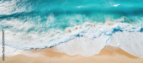 Scenic summer seascape with beautiful waves, blue sea water under sunny skies. A stunning aerial view captures the tropical beauty, ideal for a background image with copy space.