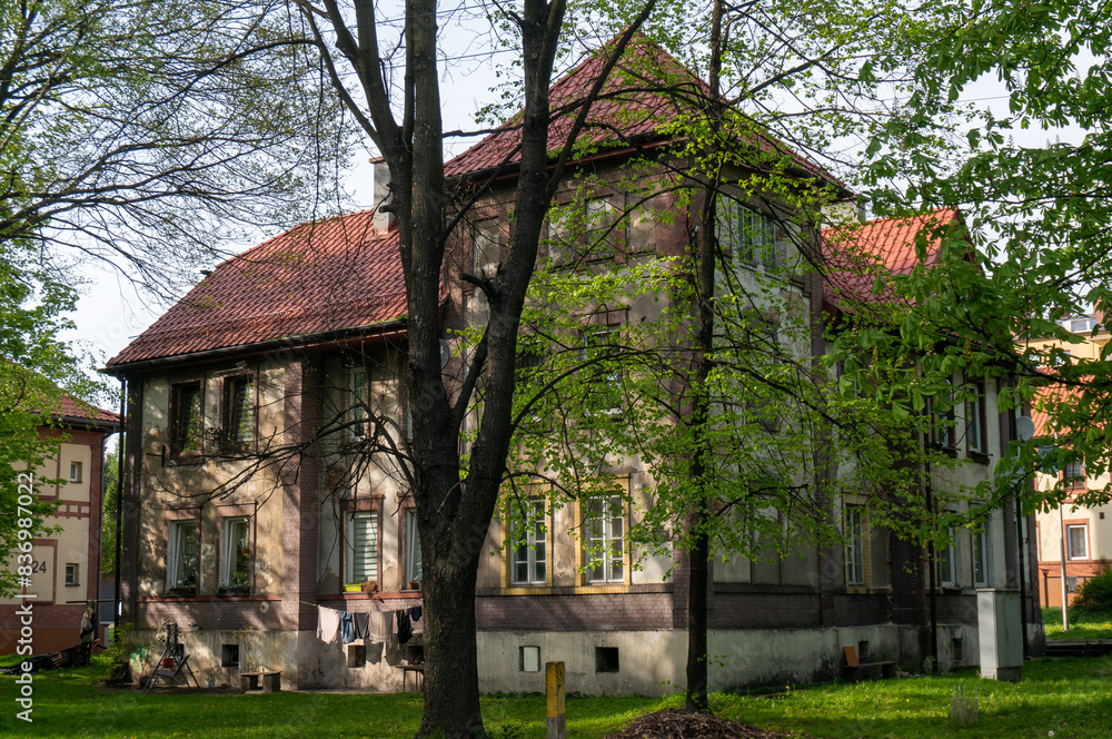 Old house for workers of so-called “Kolonia” (town district) behind the trees. Wojkowice, Poland. Old house for workers of so-called “Kolonia” (town district) behind the trees. Wojkowice, Poland.