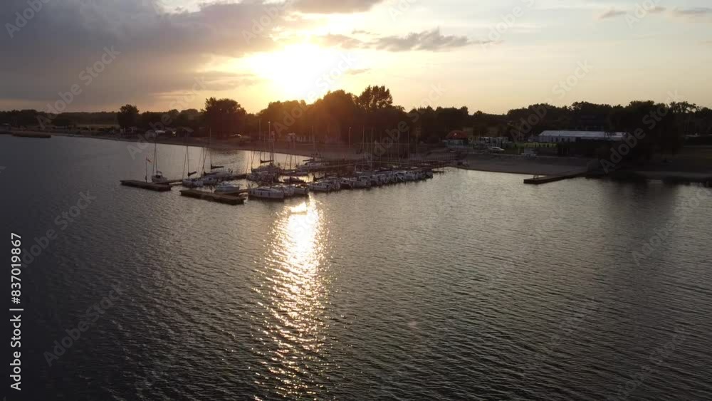 Sunset over the lake water with marina with boats sailboats yachts Sunset over the lake water with marina with boats sailboats yachts