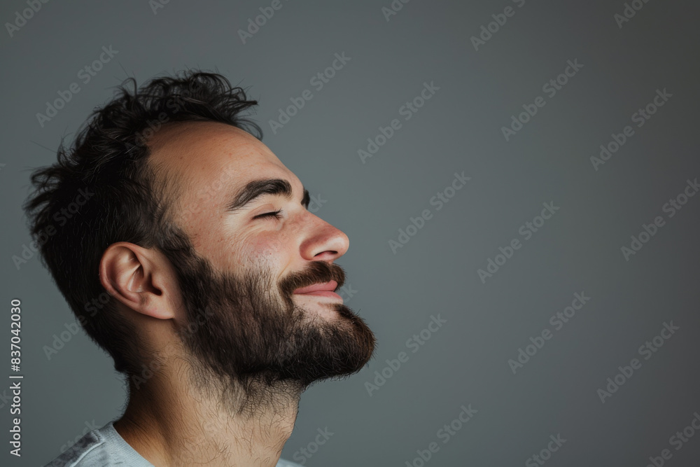 Obraz premium A close up of a man with beard and closed eyes looking to a side