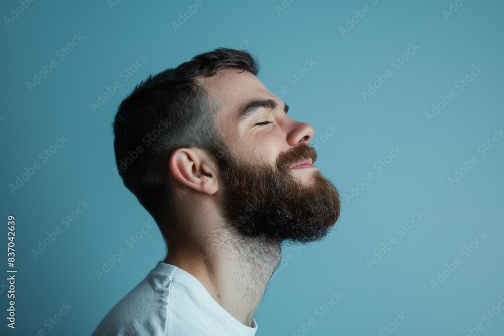 Obraz premium A close up of a man with beard and closed eyes looking to a side