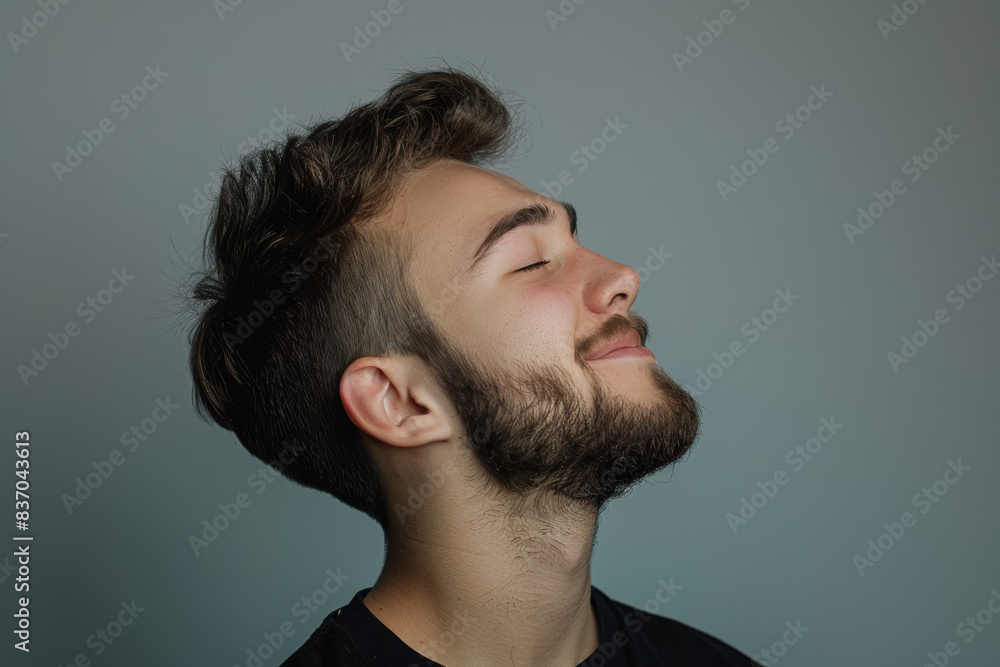 A close up of a man with beard and closed eyes looking to a side A close up of a man with beard and closed eyes looking to a side