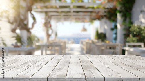 Leerer weißer Holztisch in einem sonnigen mediterranen Restaurant oder Café mit Blick auf das Meer im unscharfen Hintergrund