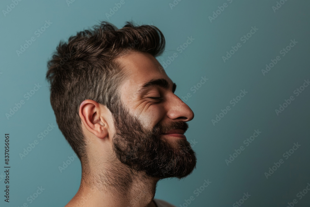 Obraz premium A close up of a man with beard and closed eyes looking to a side