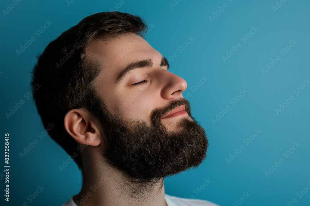 A close up of a man with beard and closed eyes looking to a side A close up of a man with beard and closed eyes looking to a side