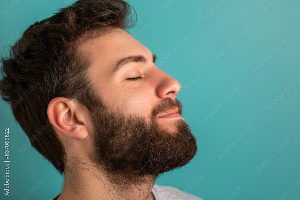 A close up of a man with beard and closed eyes looking to a side A close up of a man with beard and closed eyes looking to a side
