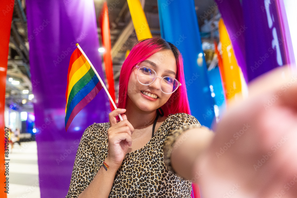 Young beautiful asian lesbian with pride movement LGBT holding rainbow flag raise up for freedom. Demonstrate rights LGBTQ celebration pride Month lesbian pride symbol. Bangkok Pride Month festival. Young beautiful asian lesbian with pride movement LGBT holding rainbow flag raise up for freedom. Demonstrate rights LGBTQ celebration pride Month lesbian pride symbol. Bangkok Pride Month festival.