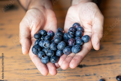 hands with handful of blueberries