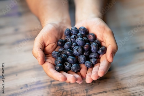 hands with handful of blueberries