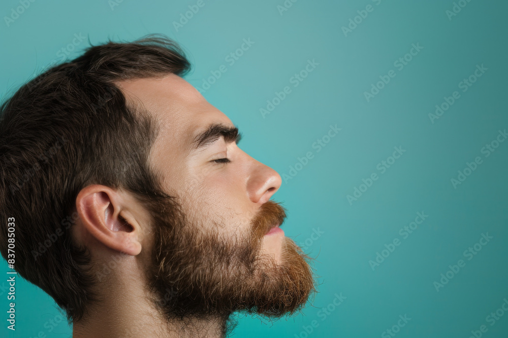Fototapeta premium A close up of a man with beard and closed eyes looking to a side