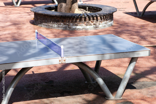 Outdoor ping pong table in a sunny park setting, ready for a game.