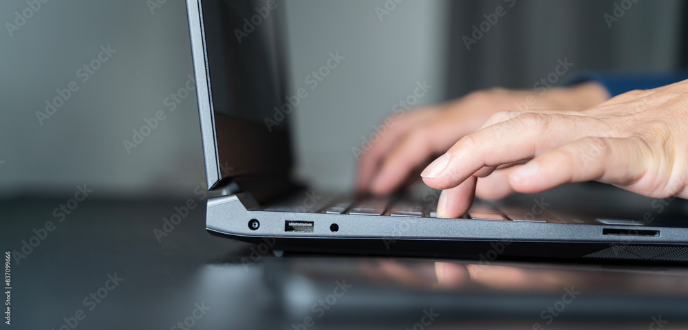 Shot of an unrecognizable businessman working on his laptop in the office. Shot of an unrecognizable businessman working on his laptop in the office.