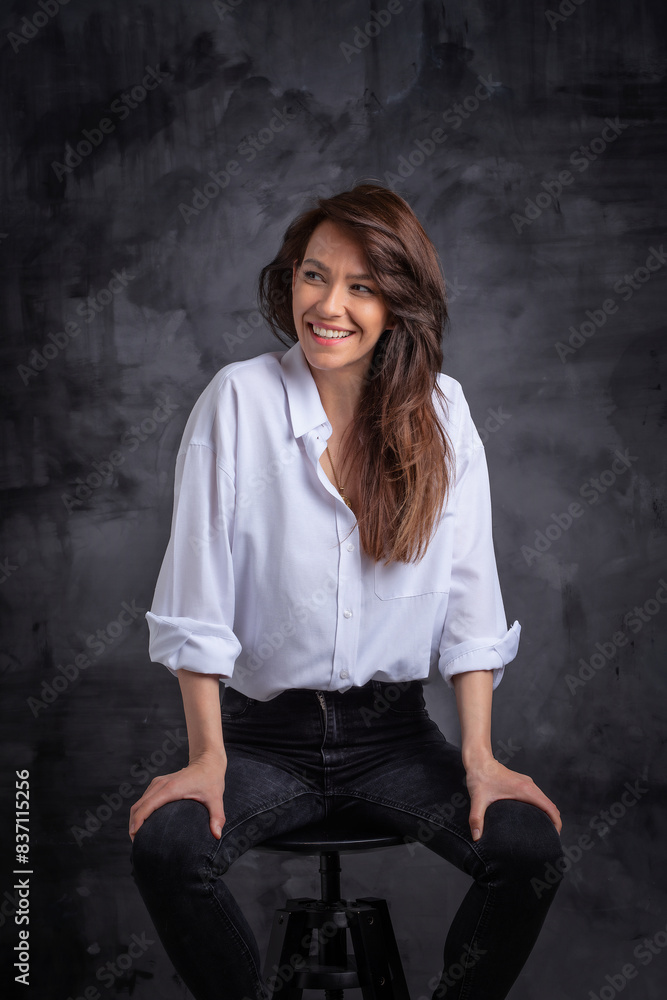 Studio portrait of an attractive brunette haired woman wearing white shirt against isolated background Studio portrait of an attractive brunette haired woman wearing white shirt against isolated background