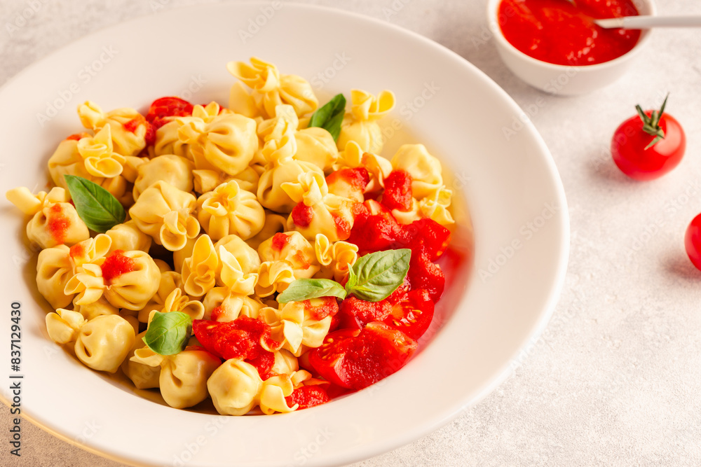 Sacсhettini pasta in a plate with tomato sauce.