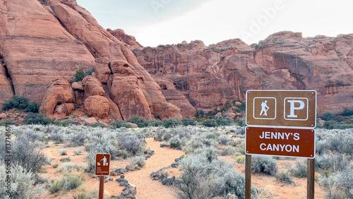 Trailhead sign and footpath for Jenny's Slot Canyon with beautiful red rock Navajo sandstone cliffs in the background - Snow Canyon State Park, St George, Utah, USA