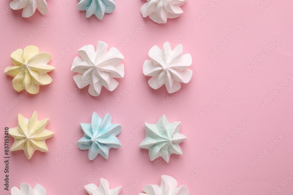 Many tasty meringue cookies on pink background, flat lay. Space for text Many tasty meringue cookies on pink background, flat lay. Space for text