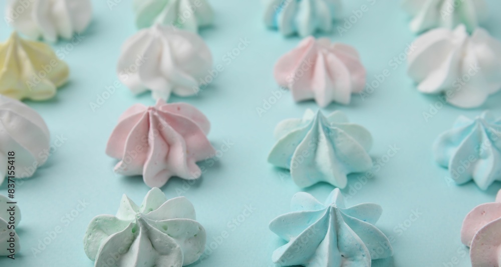 Delicious meringue cookies on light blue background, closeup Delicious meringue cookies on light blue background, closeup