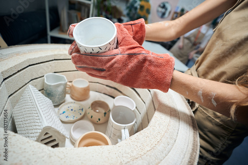 Bild auf Leinwand Unrecognizable female artisan taking glazed mug from kiln