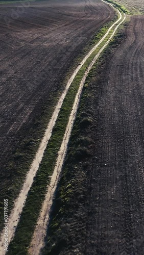 Vertical video of the markings of a dirt road from a drone view in reverse motion