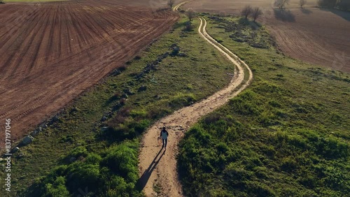 Drone view of  A person walks alone on a rural road photo