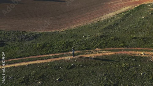 drone view surrounding A person standing alone in the middle of a road